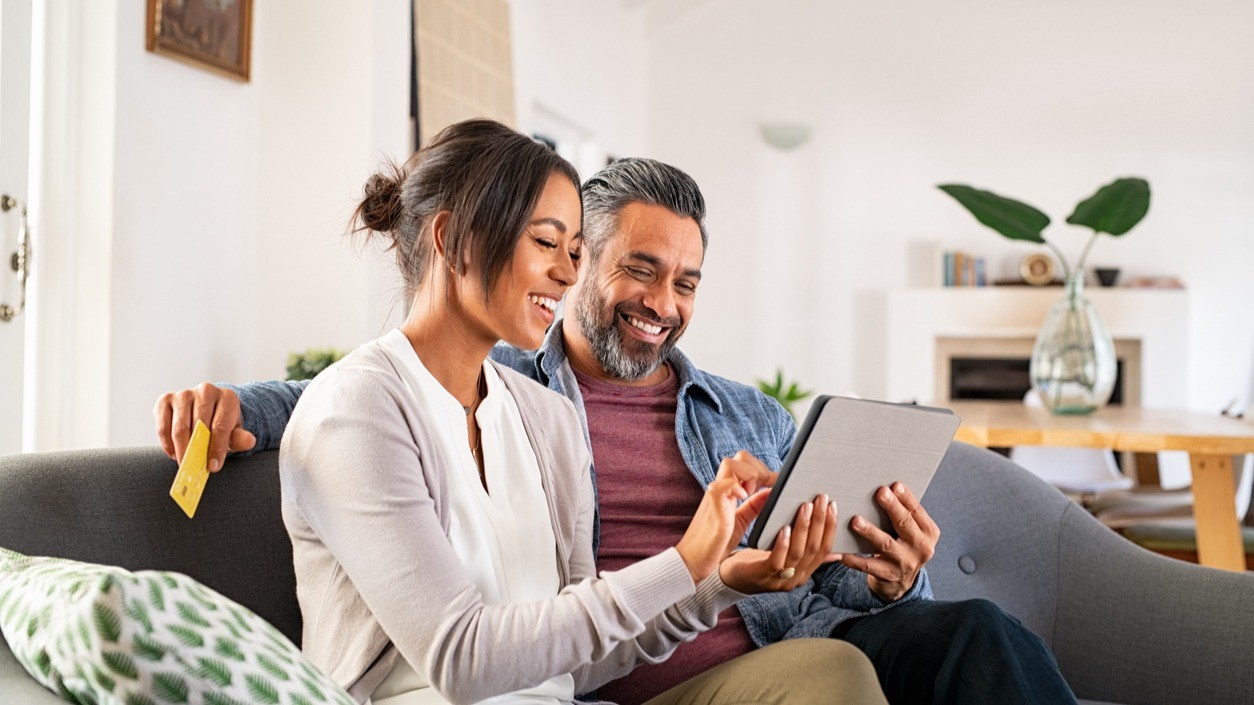 woman and man looking at tablet on couch